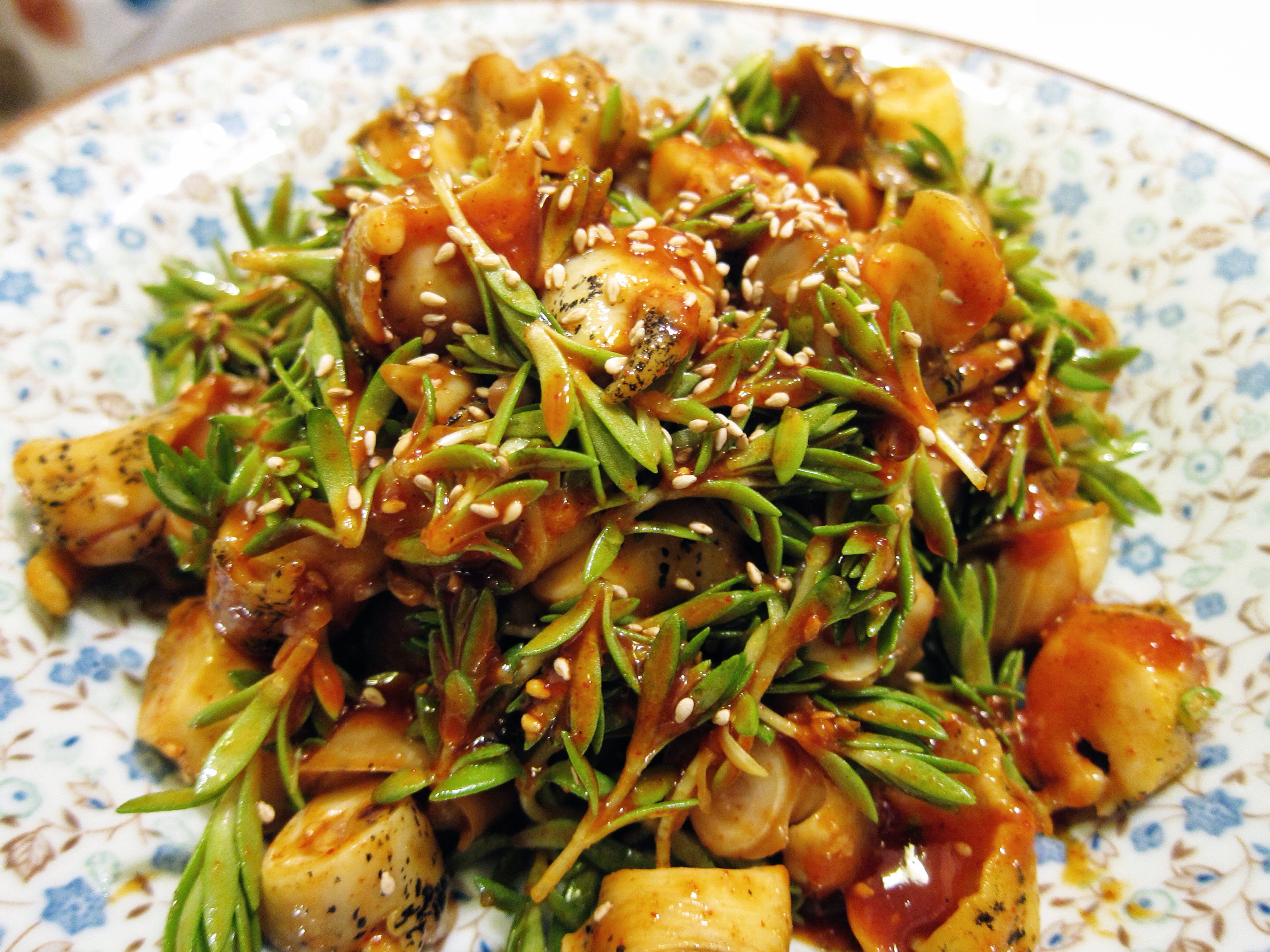 whelk with greens, sesame seeds, and red sauce