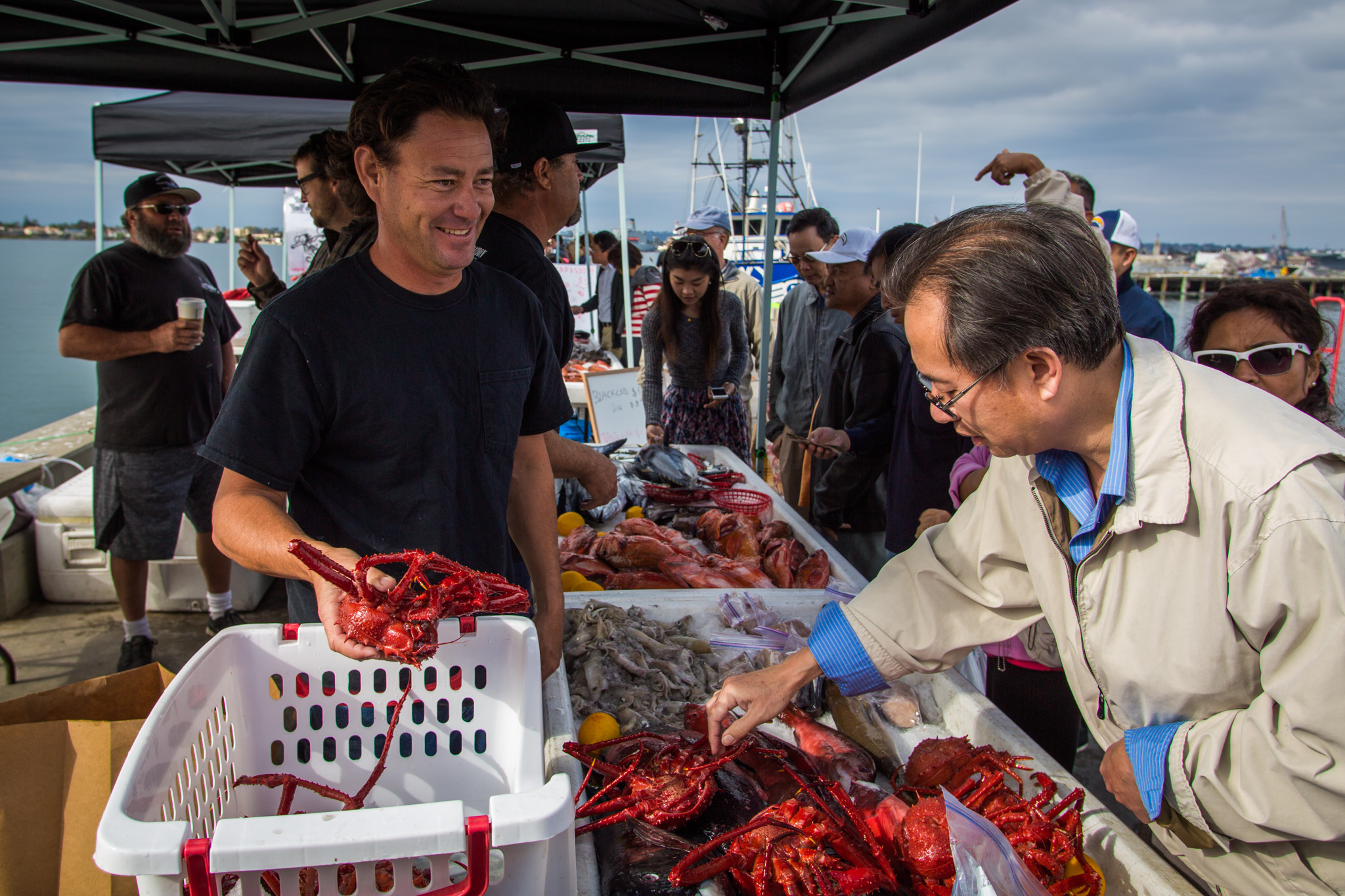 fisherman selling red king crab to a customer