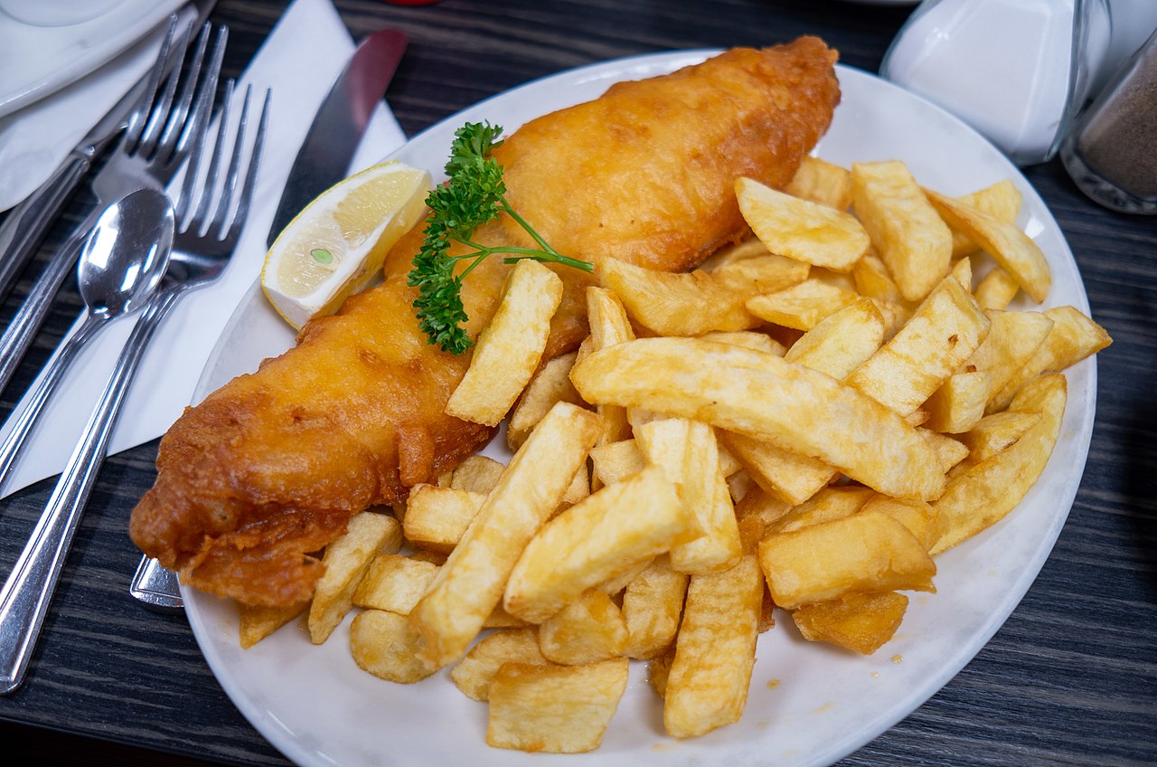 Fish and chips with parsley garnish and lemon wedge