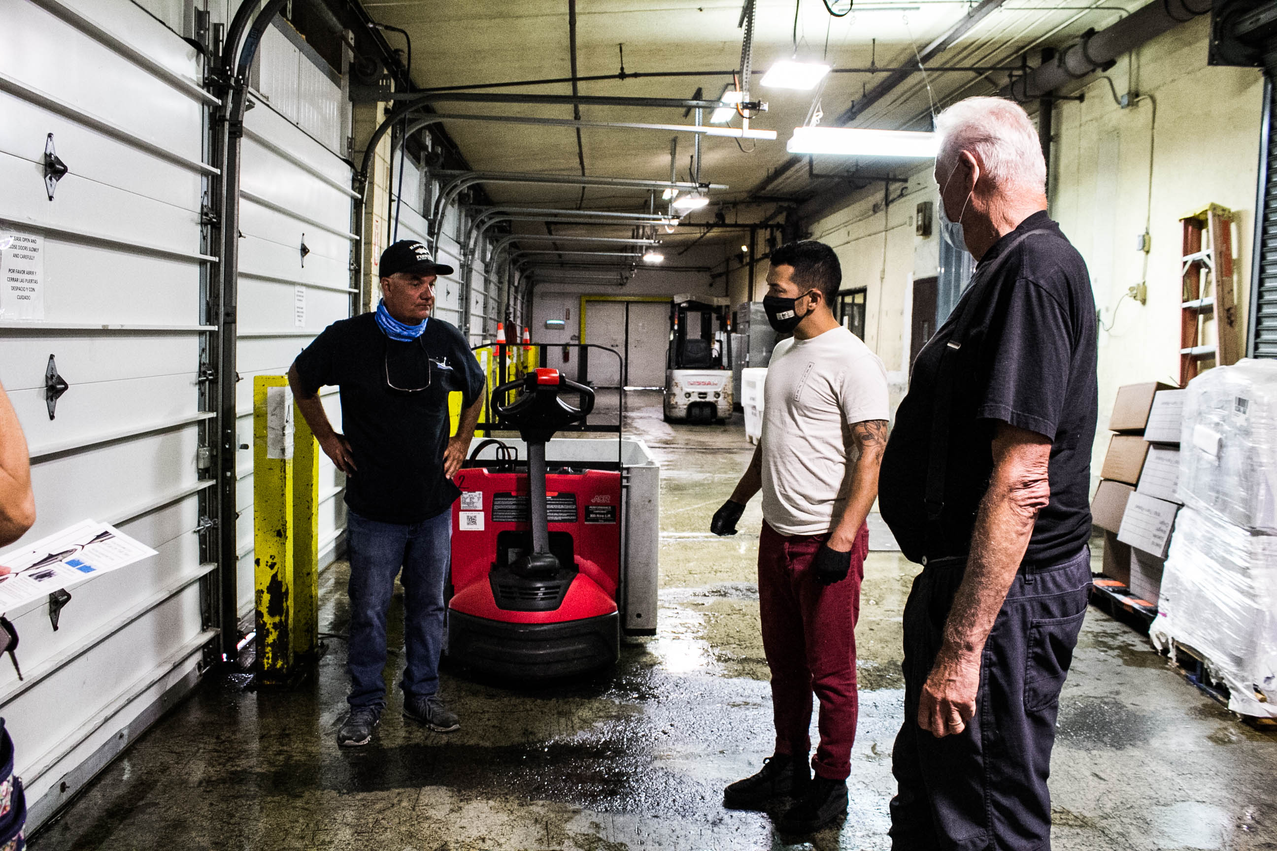 Chef Marcus Twilegar picks up albacore tuna from San Diego fisherman, David Haworth. Fisherman and project co-lead, Peter Halmay, looks on.