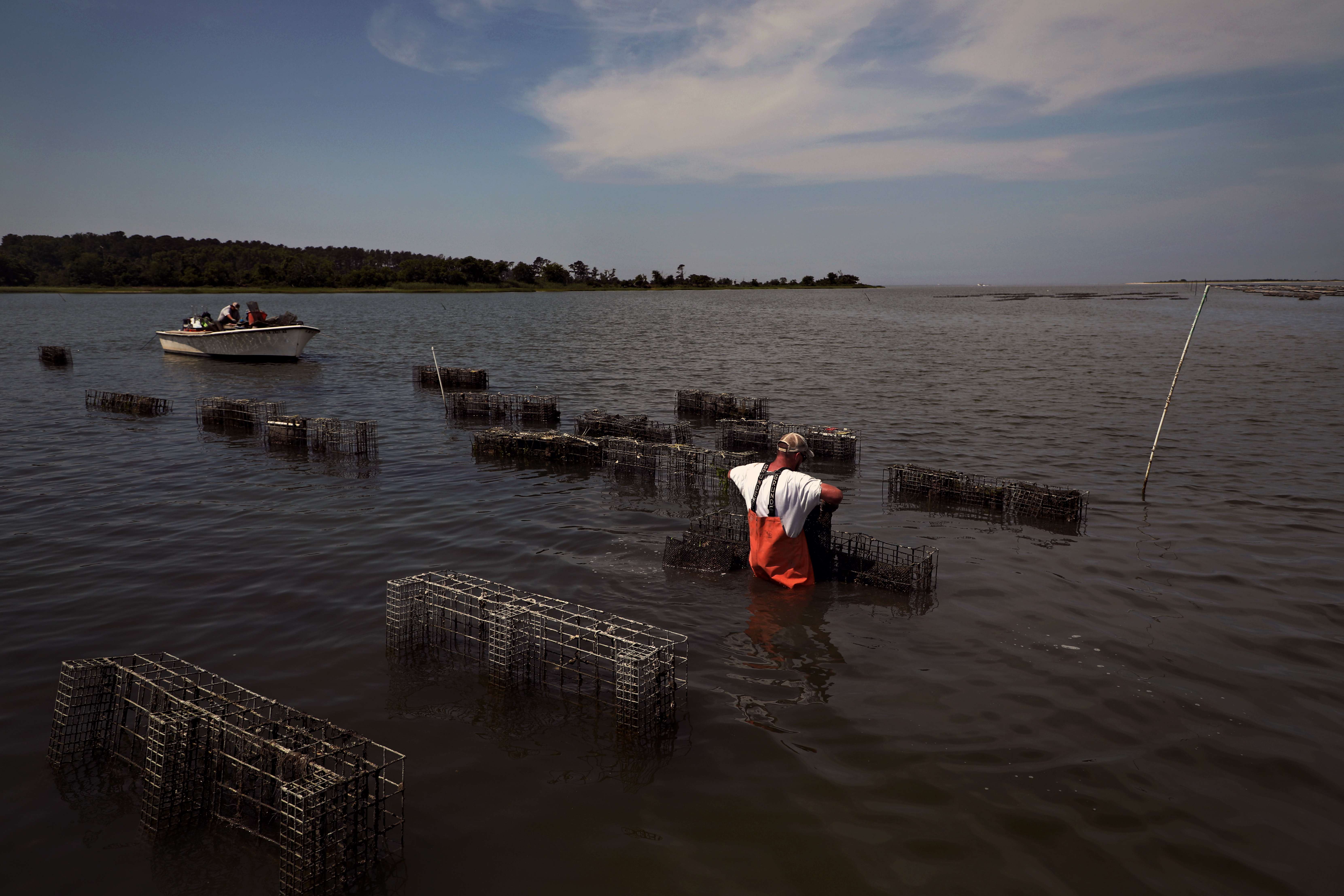 person working with floating cages 