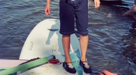 Viktoria, as a young girl, standing on a windsurfing board