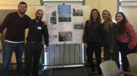 Group of fellows standing around a poster