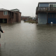 Woman measuring flood waters by houses