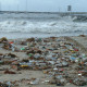 Piles of trash on beach shore.