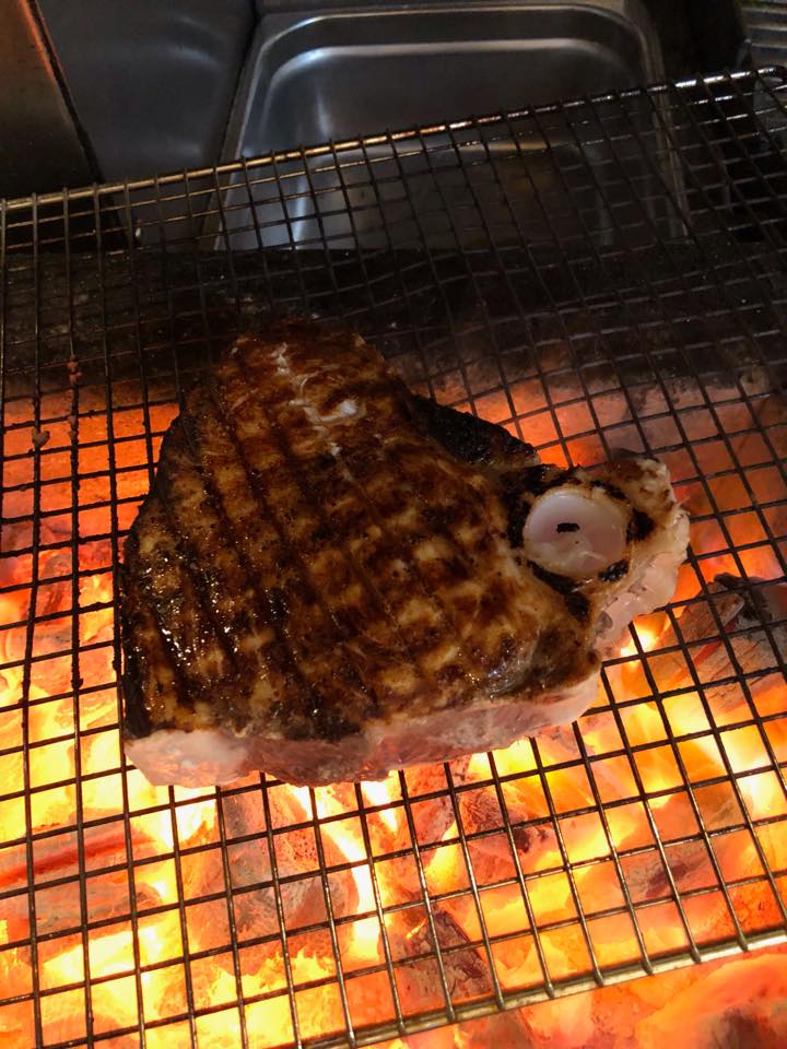 swordfish grilling over a wood fire