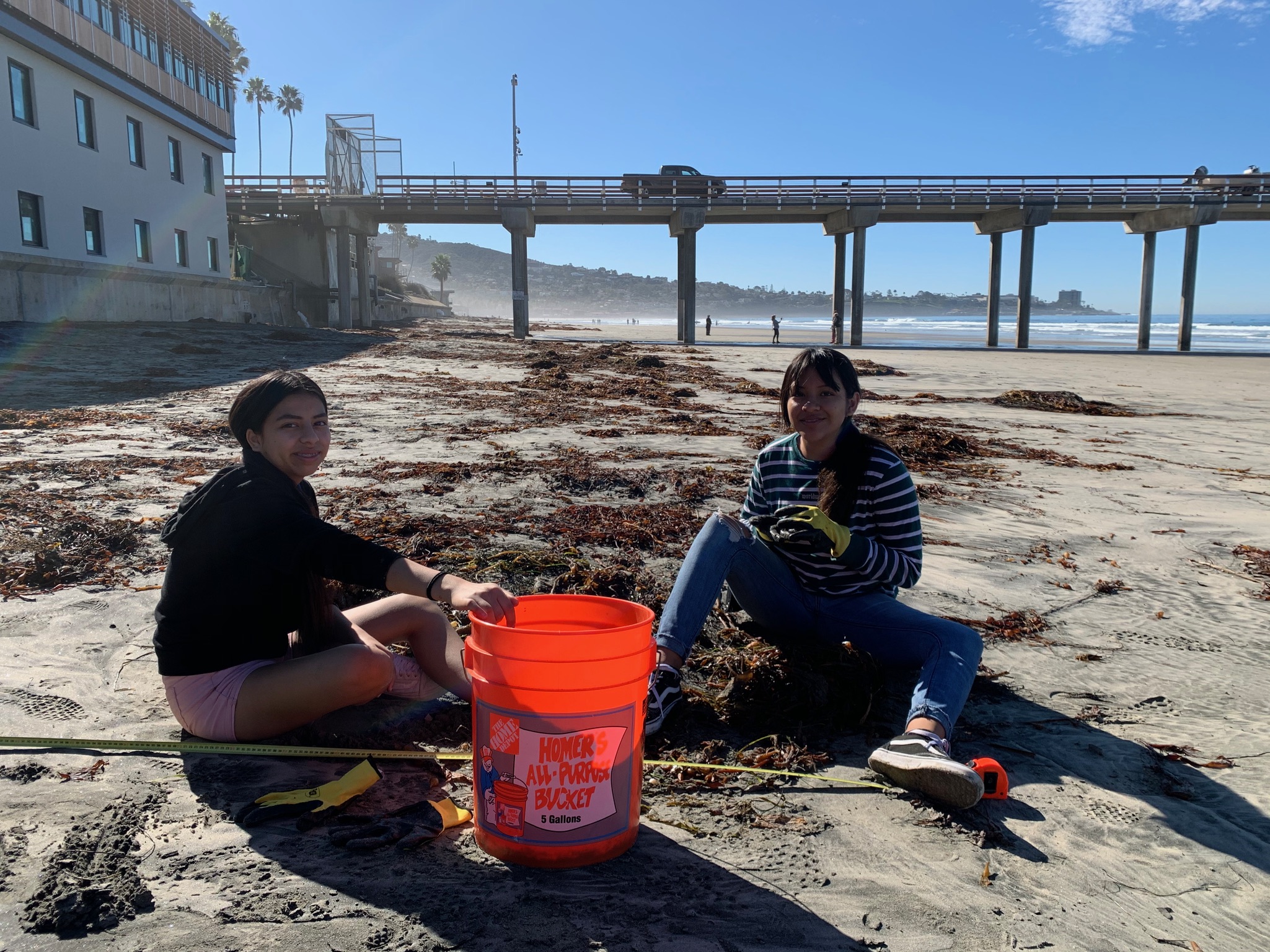 two students sitting on the beach