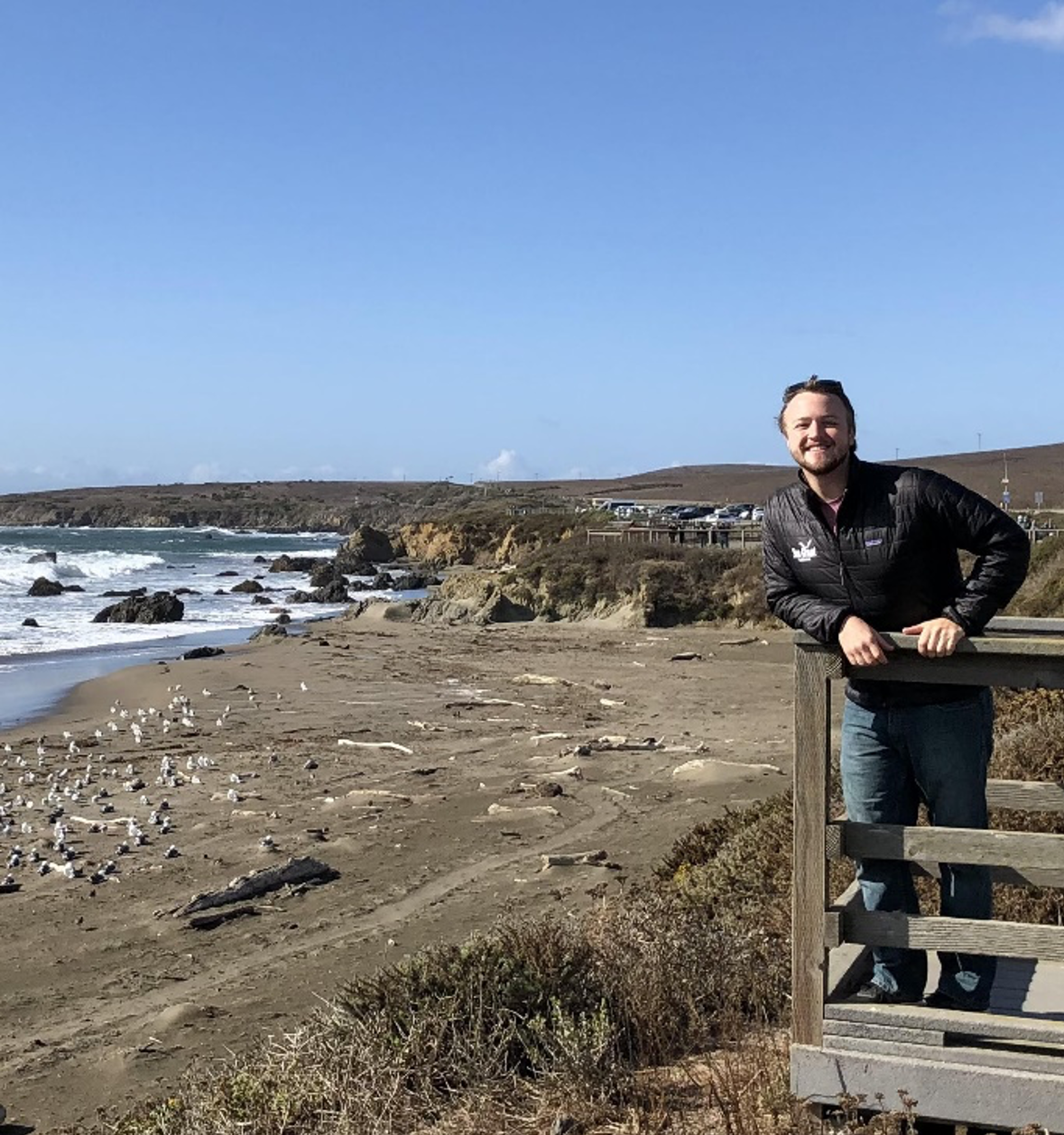 Mark Danielson standing on a wooden balcony near the coast