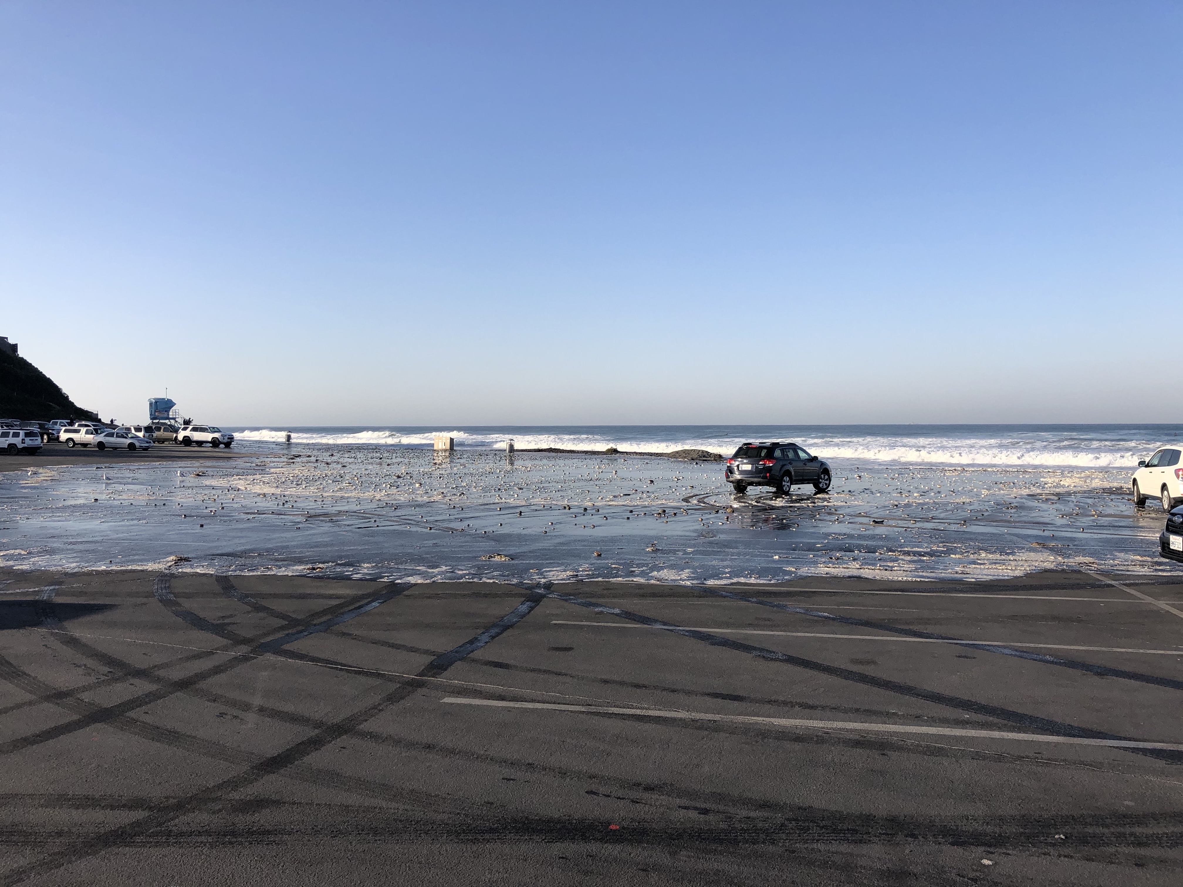 image of flooded beach parking lot caused by combined high tide and moderate swelll