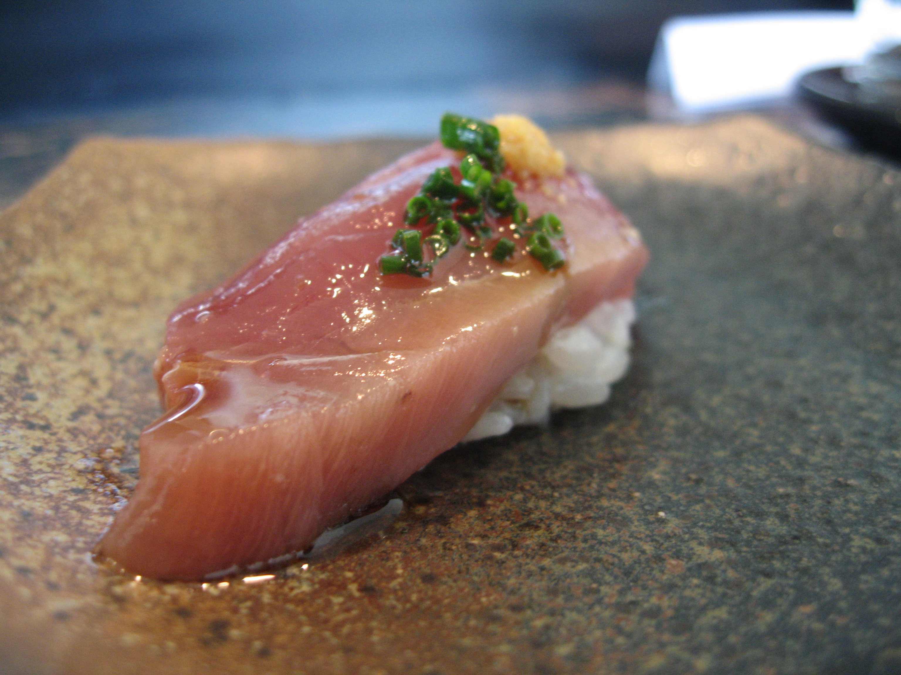 yellowtail sushi garnished with green onion and ginger